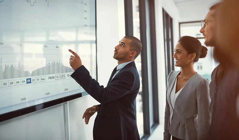 Power BI nedir – Power BI ile Microsoft ürünleri entegrasyonu anlatılırken iş insanlarının dijital ekranda rapor paylaşımı ve veri analizi yapması